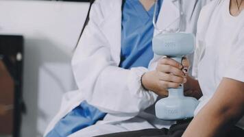 A woman is holding a dumbbell while sitting in a chair video