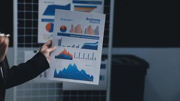 A man holding a piece of paper with graphs on it video