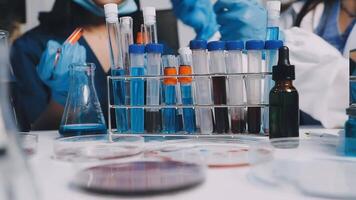 A group of people in lab coats and gloves are working on a project video
