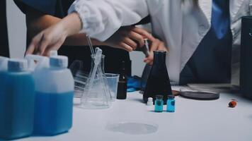 Two people in lab coats are working on a table video