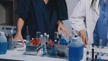Two women in lab coats working on a table video