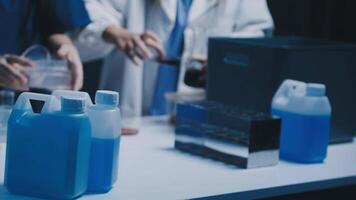 Two people in lab coats are working with blue liquid video