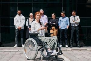 A diverse and confident group of businessmen posing together, with a businesswoman in a wheelchair radiating success, ambition, and unity, capturing the essence of a dynamic and inspiring business photo