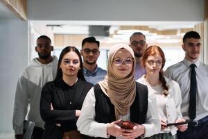A group of business professionals standing together, taking a well-deserved break from their busy workday, showcasing camaraderie, teamwork, and a moment of relaxation in their dynamic workplace photo