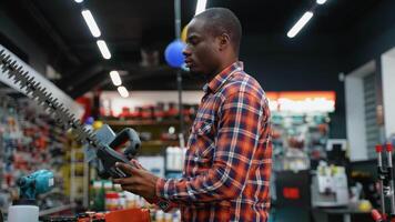 man väljer en häck trimmer i en kraft verktyg Lagra video