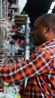 A Man Examining Power Tools in Hardware Store video