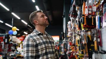 A Man Examining Bolt Cutters in a Hardware Store video