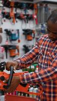 A Man Choosing a Chainsaw in a Hardware Store video