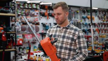 A Man Choosing a Chainsaw in a Hardware Store video