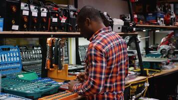 African American man carefully inspects a large tool set in a hardware store video