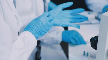en person i en labb täcka och handskar är arbetssätt på en dator video