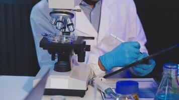 un' uomo nel un' laboratorio cappotto è utilizzando un' microscopio video