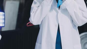A man in a lab coat is holding a blue cloth video