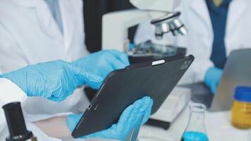 A person in a lab coat holding a tablet video