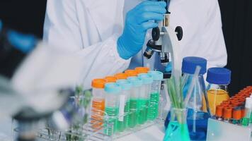 A person in a lab coat is looking at a test tube video