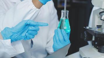 A person in a lab coat is holding a test tube video