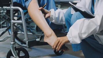 A doctor is examining a patient's leg in a wheelchair video