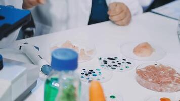 A person in a lab coat is working on a microscope video