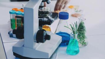 A microscope is on a table with various chemicals video