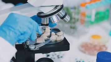 A person in blue gloves is looking at a microscope video