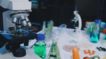 A microscope is on a table with various vegetables video