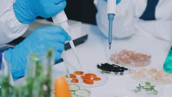 Two people in blue gloves are working on a lab table video
