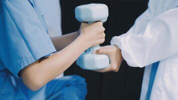 A doctor is holding a dumbbell while another person is holding it video