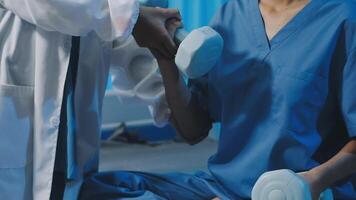 A doctor is helping a patient with a dumbbell video