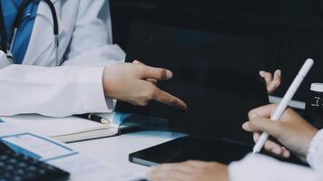 en läkare är innehav en läsplatta dator medan annan person är ser på den video