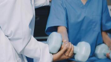 A doctor is holding a dumbbell in front of a woman video