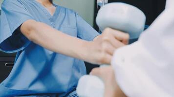 A woman in scrubs is lifting a dumbbell video