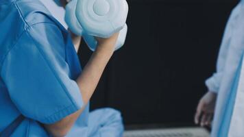 A woman in scrubs holding a white object video