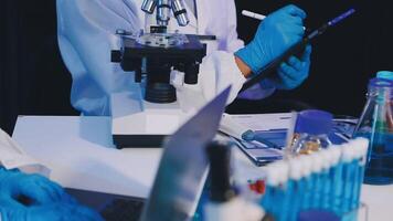 Two people in lab coats working on a computer video