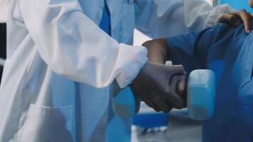 A doctor is helping a patient with a dumbbell video