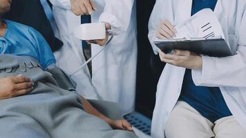 A doctor is holding a clipboard while a patient is lying on a bed video