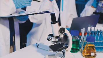 Scientists in lab coats looking at microscope video