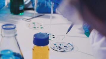A person in a lab coat is working on a test tube video