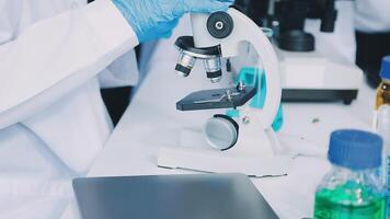A person in a lab coat is looking at a microscope video