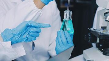 A person in a lab coat is holding a test tube video