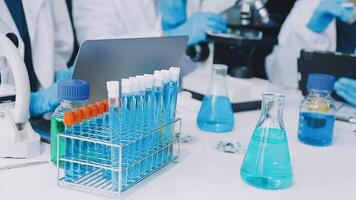 A group of people in lab coats are working on a project video