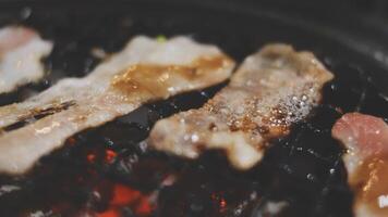 A close up of bacon being cooked on a grill video