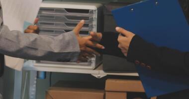 Two business people shaking hands in front of a filing cabinet video