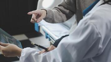 A doctor is pointing at a tablet computer video