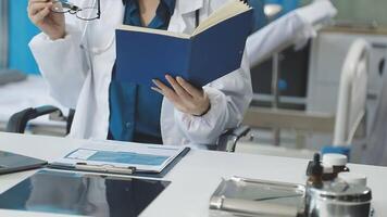 A woman in a lab coat is reading a book video