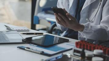 A doctor is using a cell phone while sitting at a desk video
