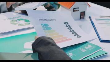 A person is holding a paper with a green energy chart video