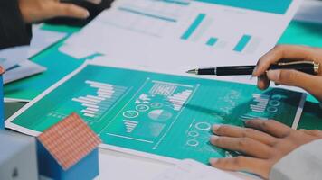 Business people working on a document with graphs and numbers video