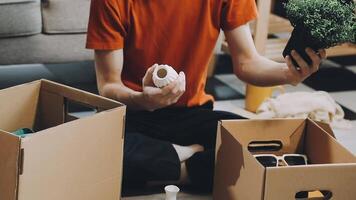 A man is sitting on the floor with boxes and plants video