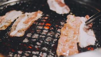 Bacon on a grill with tongs video