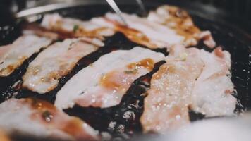 A close up of bacon being cooked on a grill video